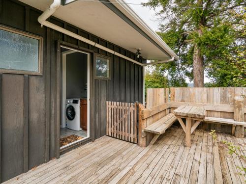 a wooden deck with a bench on a house at Paku View Retreat - Tairua Holiday Home in Tairua