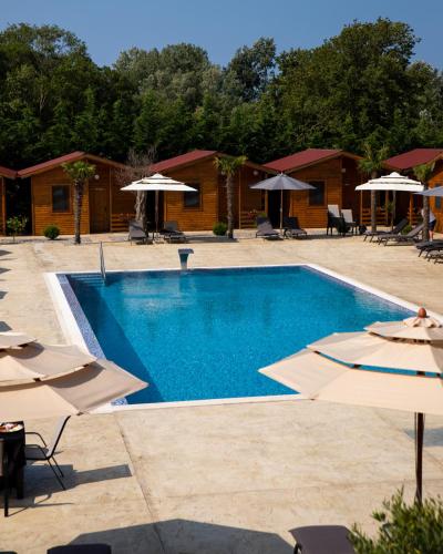 a swimming pool with chairs and umbrellas in a resort at Sunny Garden Pansion in Ulcinj