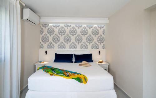 a bedroom with a white bed with blue pillows at Blue View Villas in Stalida