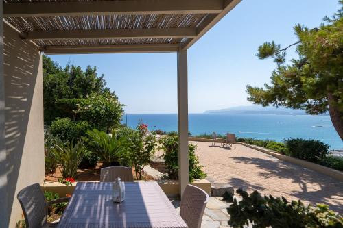 a table and chairs on a patio with a view of the ocean at Blue View Villas in Stalida