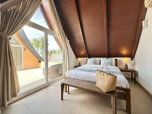 a bedroom with a bed and a large window at Sunrise Beach Villa in Ko Chang