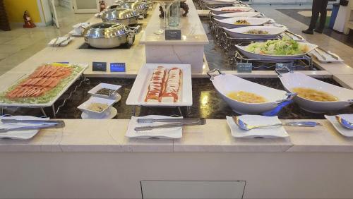 una línea de buffet con platos de comida y tazones de comida en Ecograd Hotel, en Suncheon