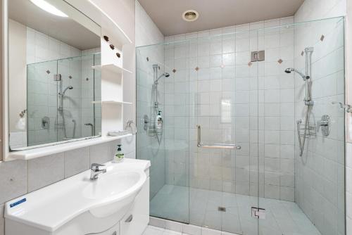 a bathroom with a shower and a sink and a toilet at Seascape Point - Mahinepua Bay Clifftop Retreat in Mahinepua