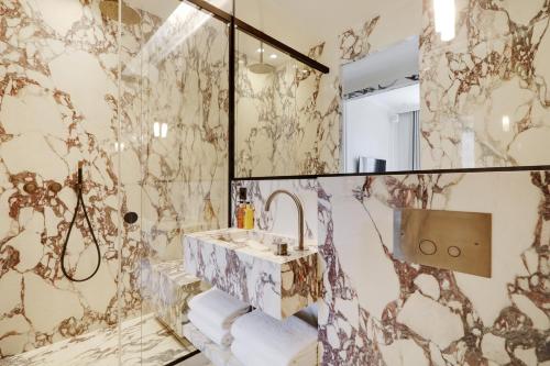 un bagno con lavandino e specchio di TheLander - Serviced Apartments in Louvre - Rivoli a Parigi