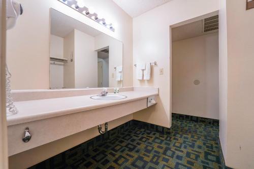 a bathroom with a sink and a large mirror at Royal Plaza Inn in Indio