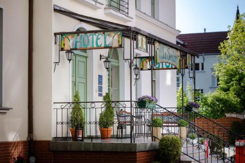 a building with a balcony with potted plants on it at Villa Sedan - Destigo Hotels in Sopot