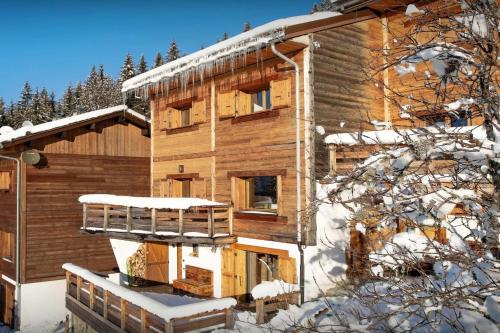une cabane en rondins dans la neige avec un balcon dans l'établissement Chalet Zamaro - OVO Network - OVO Network, à La Clusaz