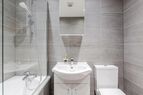 a bathroom with a sink and a toilet and a shower at Watford Town Centre, Serviced One Bed Flat with choice of King or Twin Beds, Sleeps Up To 4 Sharing, FREE WiFi and FREE Movies in Watford