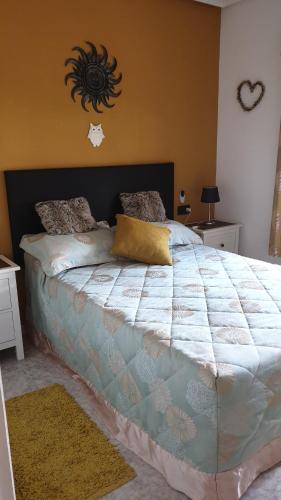 Un dormitorio con una cama grande con una manta. en Casa Millie en Playa Flamenca