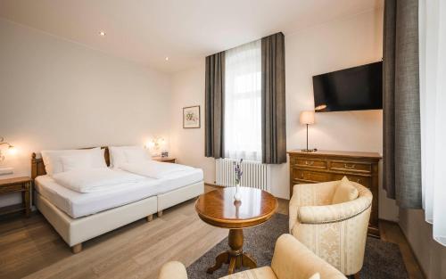 a hotel room with a bed and a table at Hotel Villa Kastelruth in Castelrotto