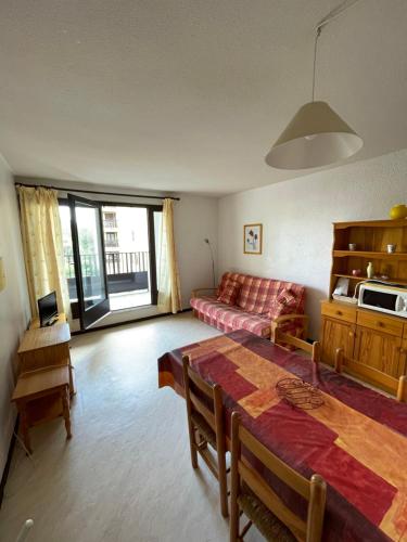 a living room with a table and a couch at Réf 413 Seignosse océan, studio alcôve à proximité immédiate de la plage et des commerces, 4 personnes in Seignosse