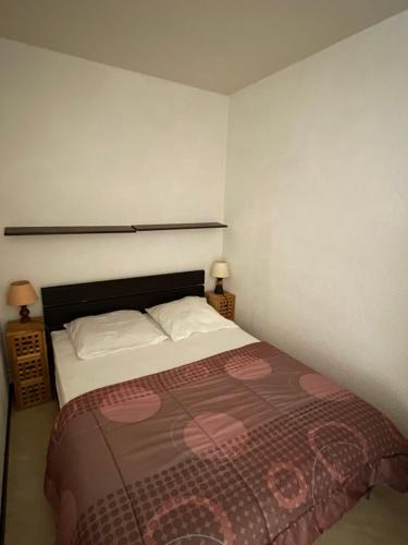 a bedroom with a bed and two night stands at Réf 413 Seignosse océan, studio alcôve à proximité immédiate de la plage et des commerces, 4 personnes in Seignosse