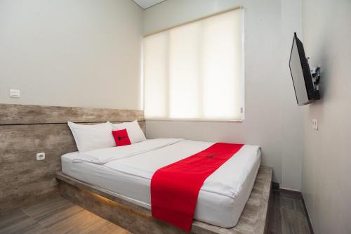 ein Schlafzimmer mit einem großen Bett mit einer roten Decke in der Unterkunft RedDoorz Plus at Eskole ITERA Lampung in Lampung