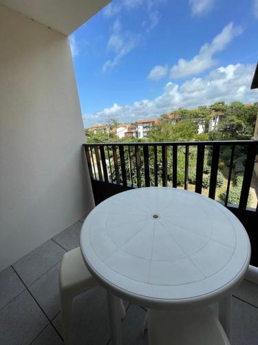 a white table and chairs on a balcony at Réf 413 Seignosse océan, studio alcôve à proximité immédiate de la plage et des commerces, 4 personnes in Seignosse