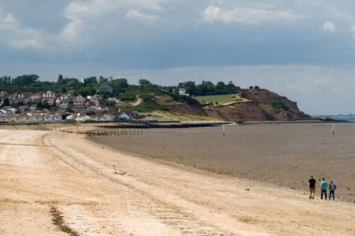 a group of people walking on the beach at Sanity Sanctuary in Leysdown-on-Sea