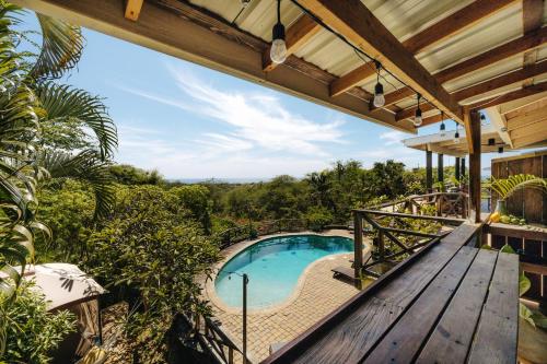 una terraza de madera con vistas a una piscina. en The Koi House with Pool, en Kailua-Kona