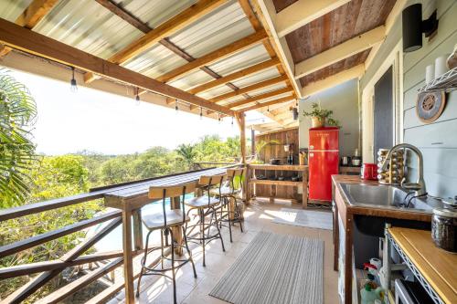 una cucina con bar e un balcone con vista di The Koi House with Pool a Kailua-Kona