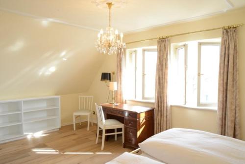 - une chambre avec un bureau, un lit et une fenêtre dans l'établissement Haus Traumstraße, à Witsum