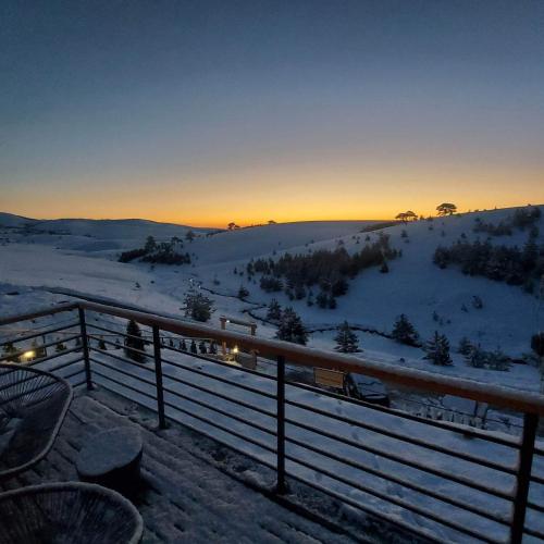 a view of a snow covered hill with a fence at Wild nest Deer Lux in Zlatibor