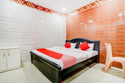a bedroom with a bed and a chair in it at Hotel Aroma Classic Near Nampally Main Railway station in Hyderabad