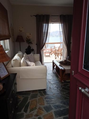 a living room with a white couch and a table at Calma in Perdika