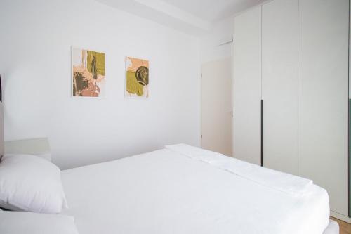 een witte slaapkamer met een bed en een schilderij bij LUXURY Rooftop 23 in Tirana
