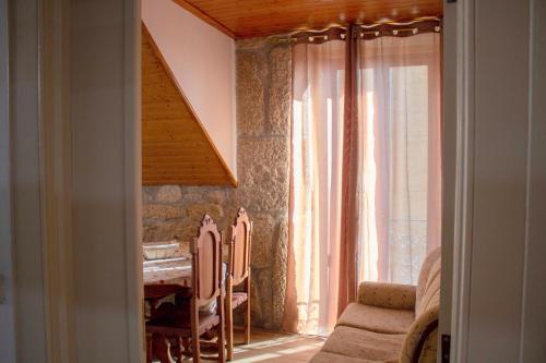 une chambre avec une table, des chaises et une fenêtre dans l'établissement Casa da Carreira de Loriga, à Loriga