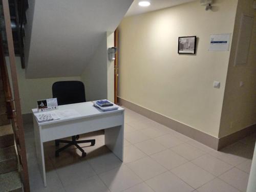 una oficina con escritorio y silla junto a una pared en Room in Guest room - H Individual In Reformed Residence has wifi center num210, en Madrid