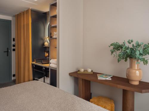 a room with a table with a potted plant on it at Boudoir des Muses in Paris