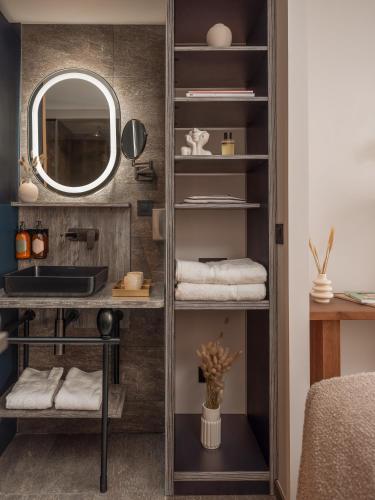 a bathroom with a mirror and a shelf with towels at Boudoir des Muses in Paris