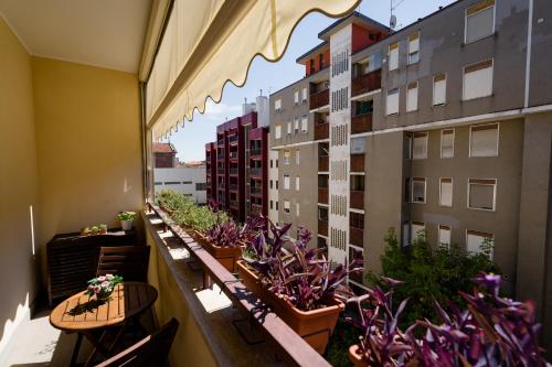een balkon met tafels en potplanten en gebouwen bij Oxilia Flat - Loreto District in Milaan