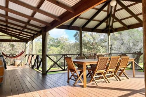 a wooden deck with a table and chairs on it at Pine View Cottage - Margaret River in Cowaramup