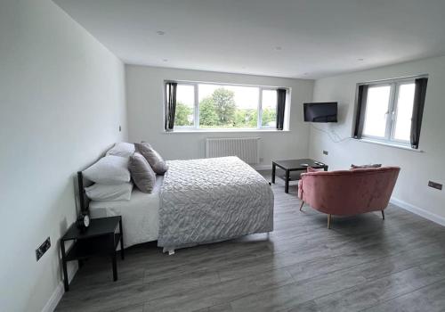 a bedroom with a bed and a television and a tub at Studio apartment in Harefield in Harefield