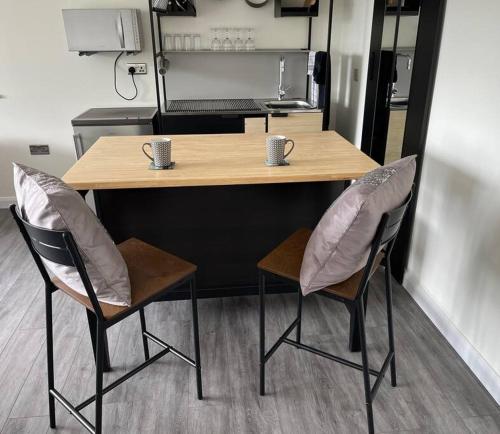 a table and two chairs in a room with a kitchen at Studio apartment in Harefield in Harefield
