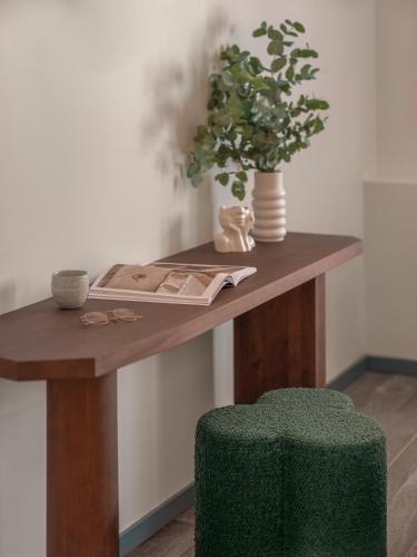 a table with a plant and a green stool at Boudoir des Muses in Paris