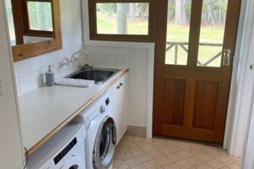 a kitchen with a sink and a washing machine at Pine View Cottage - Margaret River in Cowaramup