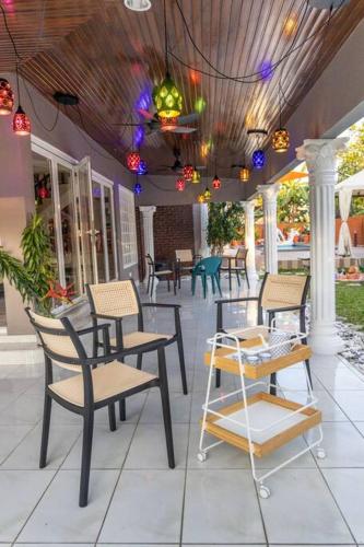 a group of chairs and tables on a patio at Villa 23 - 4B/4B/PrivatePool/BBQ in Petaling Jaya