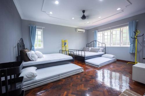 three beds in a room with blue walls and wooden floors at Villa 23 - 4B/4B/PrivatePool/BBQ in Petaling Jaya