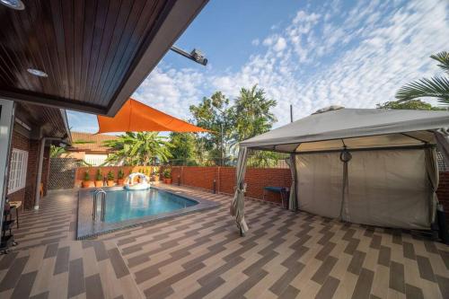 a house with a swimming pool and an umbrella at Villa 23 - 4B/4B/PrivatePool/BBQ in Petaling Jaya