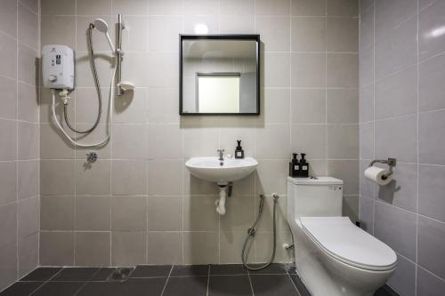 ein Badezimmer mit Toilette, Waschbecken und Spiegel in der Unterkunft Beautiful 3B2B for 6 pax w Pool - Subang Jaya in Subang Jaya
