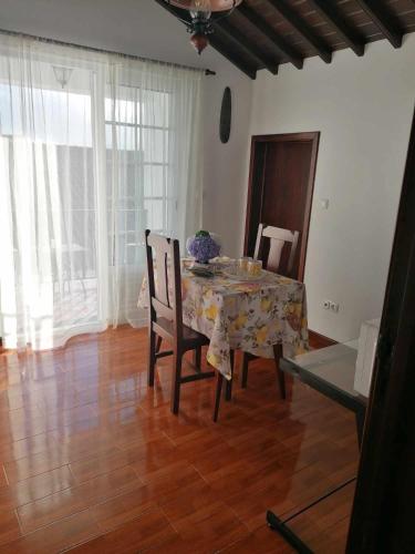 a dining room table with chairs and a vase on it at Vila Mendonça in Povoação