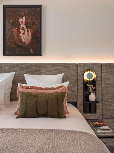 a bedroom with a bed with a headboard and a painting at Boudoir des Muses in Paris