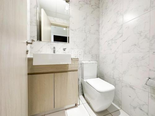 a white bathroom with a toilet and a sink at ANW Vacation Homes - One bedroom apartment Afnan 4 Midtown Dubai Production City in Dubai