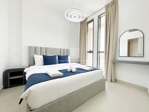 ANW Vacation Homes - One bedroom apartment Afnan 4 Midtown Dubai Production City في دبي: غرفة نوم بسرير كبير ومرآة