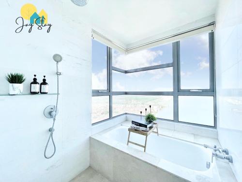 a white bathroom with a tub and a window at SilverScape Residence I Luxury 2-4 BR I 6-11 pax I Bathtub I Seaview I Infinity Pool I Jonker St I City Centre by Jay Stay Management in Melaka