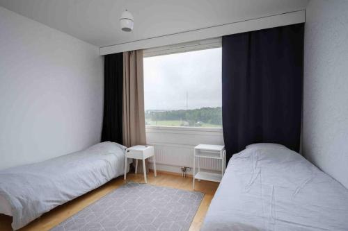 um quarto com 2 camas e uma janela em Saris 4 bedroom apartment with view em Turku