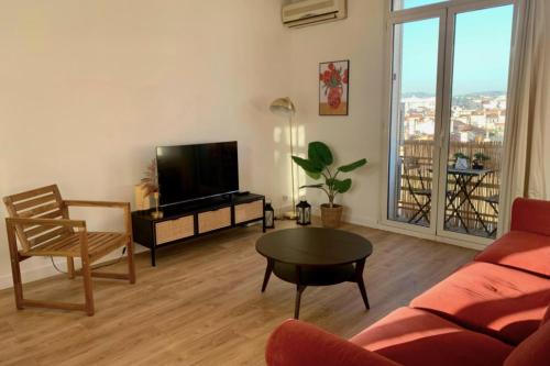 sala de estar con sofá, TV y mesa en Central and blight flat with balconies, en Marsella