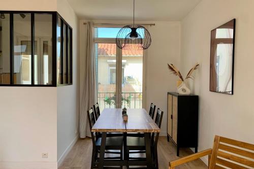 comedor con mesa, sillas y ventana en Central and blight flat with balconies, en Marsella