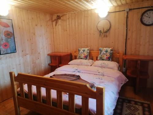 um quarto com uma cama num quarto de madeira em Cabana nea Nicu em Bălceşti