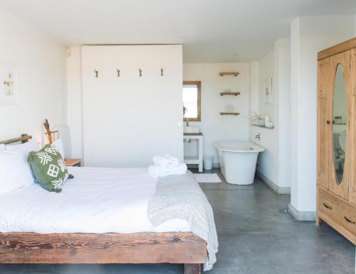 a bedroom with a bed and a bath tub at Driftwood in Paternoster